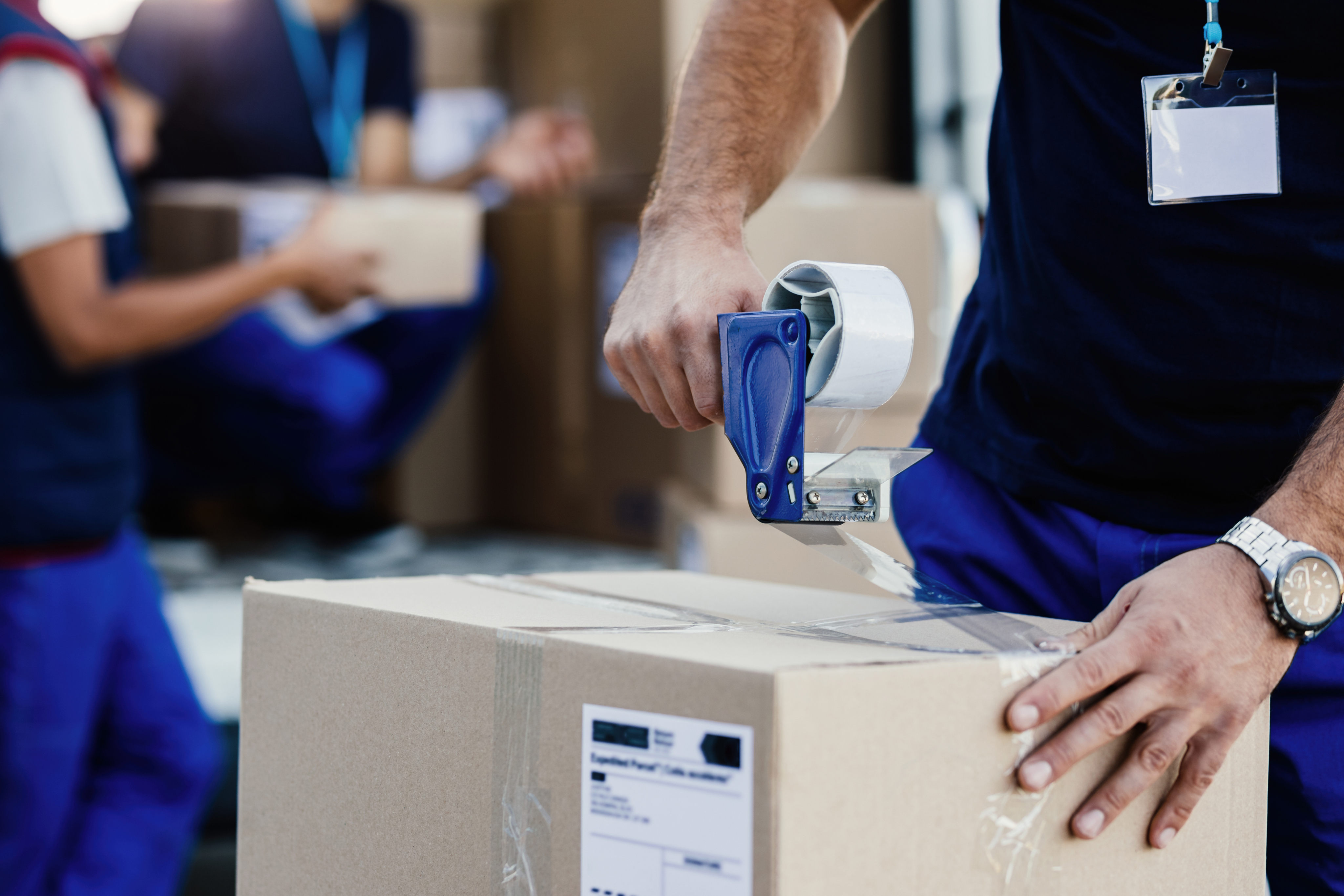 A worker taping up a shipment box
