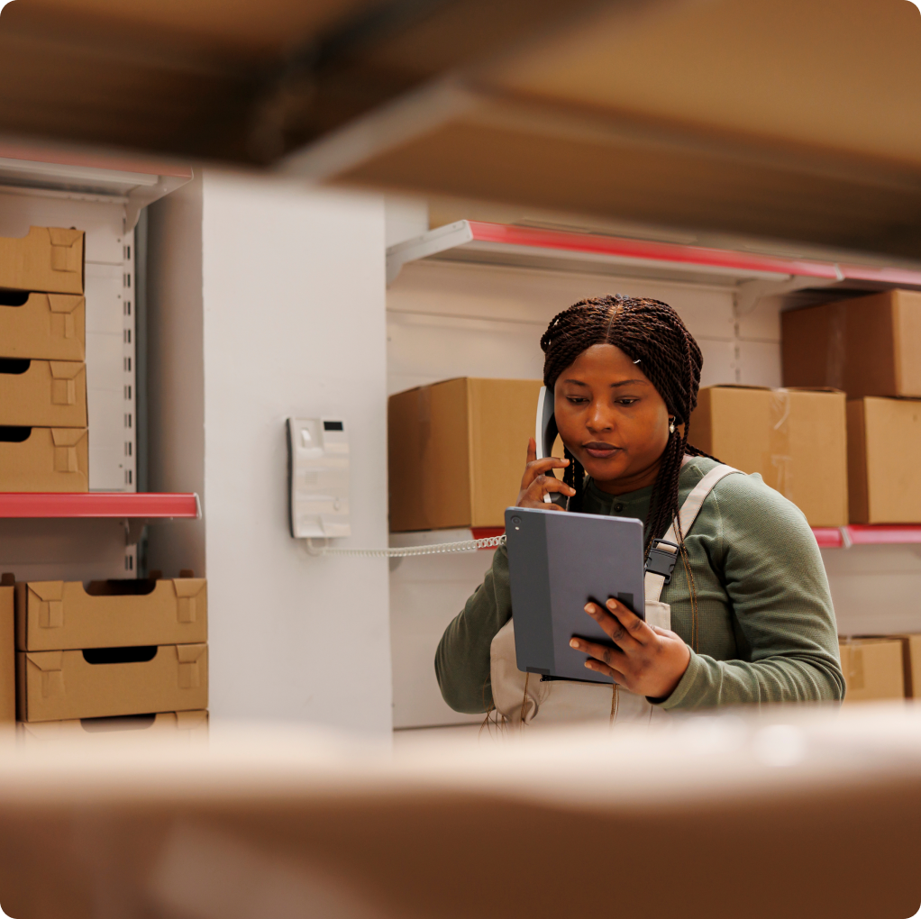 A retail supervisor checking stock on a tablet in a stockroom